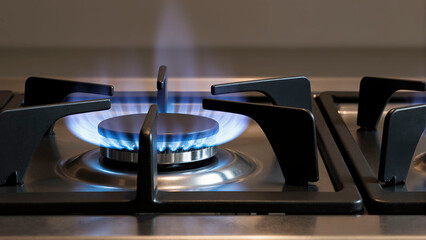 Gas stove burner lit, close up view. Modern kitchen appliance for cooking food.