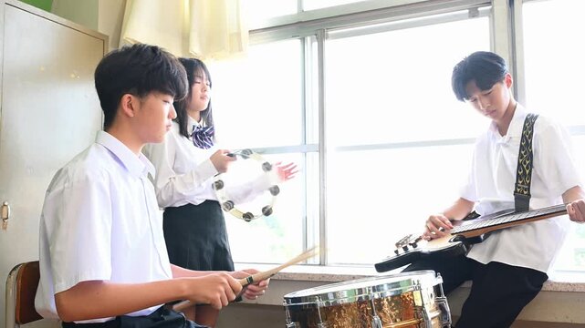 文化祭に向けてバンド練習をする生徒たち　学校の教室での青春イメージ