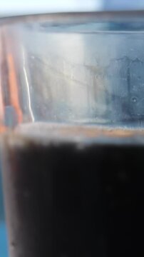 shake the drink hand from a can pours Cola into a highball glass. The camera flies around. Parallax effect. Dark background.