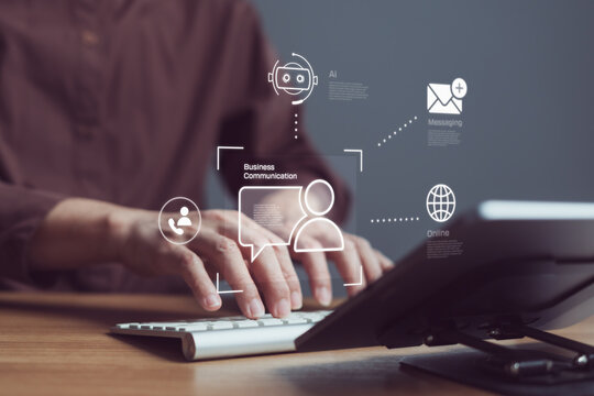 Business professional using keyboard with AI chatbot and messaging icons on virtual interface, for efficient digital communication in modern business