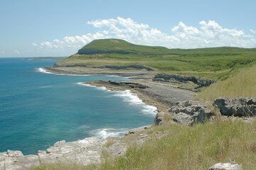 Obraz premium Coastal landscape with rocky cliffs and serene ocean view on a clear sunny day