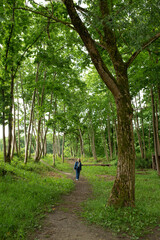 girl in denim suit walking along forest road
