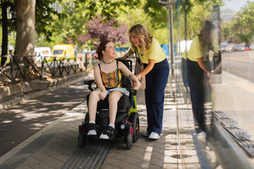 Volunteer helping young disabled woman on wheelchair at bus stop