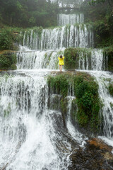 Posing in front of the four-tiered Synrangkhit waterfall in Meghalaya, India