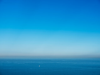 lonely sailing boat in channel near dover on early foggy morning