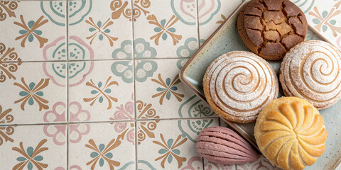 Mexican sweet bread conchas in assorted colors placed on talavera tiled surface suitable for bakery branding product packaging mexican cuisine projects and culinary promotional materials