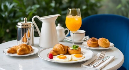 Fototapeta premium A delicious breakfast spread with fresh orange juice, eggs, croissants, and pastries, set outdoors
