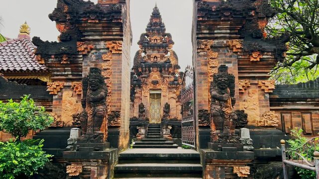 A sacred Balinese temple gate crafted in stone with detailed statues and spaces for offerings represents spiritual balance and reflects the island deep cultural and religious heritage.
