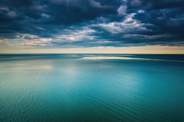 Obraz premium An aerial perspective of the heavens. Over the water, a somber blue atmosphere is visible. Aerial photos capturing the sky above a body of water.