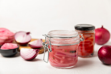 Pickled onions in a glass jar on the table. pickled red onion. Vegetarian spicy dish. Delicious homemade marinated pickled purple onions . Space for text. Copy space.