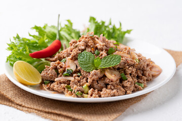 Local Thai food, Spicy minced pork salad (Larb Moo) eating with fresh vegetables on white background