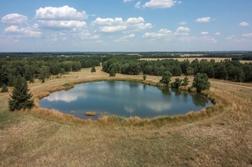 Obraz premium Bird's-eye perspective of a tiny pond and marshland in a valley