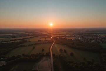 Fototapeta premium Sunset panorama over a vast plain with flowers and green fields under a summer sky