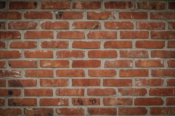 Obraz premium Vintage brick wall with red textured window and historical ambiance