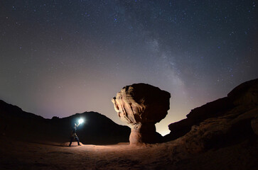 night photo of a man with light near Mushroom Rock at Timna National Park with the Milky Way