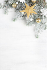 Christmas and New Year background with holiday decorations.
 Branch of fir tree with Сhristmas ornaments on old white wooden shabby background with empty space for text.