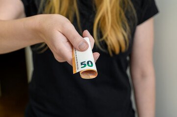 A woman shows a 50 euro banknote