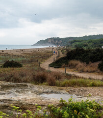Sandy beach path with view of Tamarit Castle in Altafulla, Spain