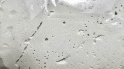 abstract white cement wall texture with air bubbles and cracks creating raw industrial surface ideal for modern wallpaper or minimalist banner background