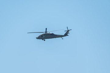 Military helicopter flying in clear blue sky