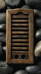 Wooden shutter with horizontal slats set against a dark grey pebbled stone background, vertical orientation