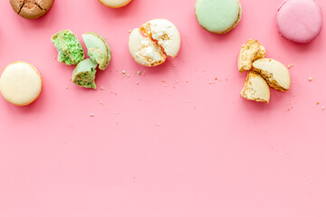Brignt macarons for sweet break on pink background top view mock up