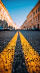 Asphalt city street view, perspective with double yellow line, buildings blurred against a blue sky in the distance