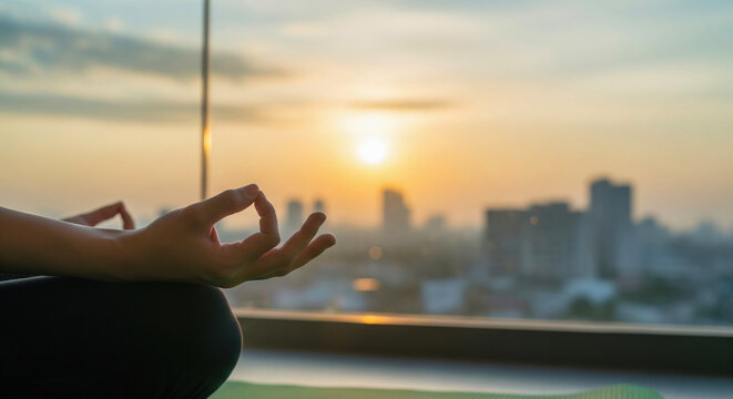 A person meditating in the morning on a balcony with soft, natural daylight and a city view