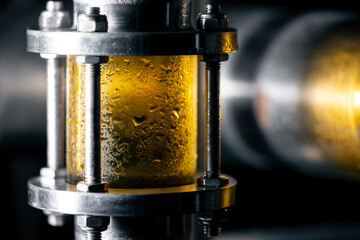 Close-up view of beer brewing process in modern brewery pipeline system