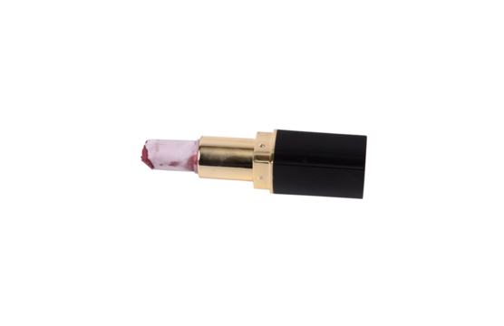 Used pink lipstick with elegant black and gold case a dark background.