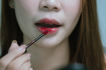 Obraz premium A young woman applies makeup with a brush, smiling confidently, showcasing flawless skin, beauty, elegance, skincare routine, and radiant facial appearance.