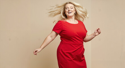 Happy plus-size woman dancing in red dress against beige background  