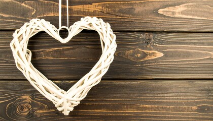 White wicker heart decor on dark wood