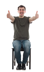 Excited man seated on a chair showing thumbs up, positive feedback, liking gesture. Positive male full length sitting portrait isolated on transparent background