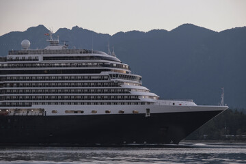 Modern classic cruiseship or cruise ship liner Nieuw Amsterdam arrival into Vancouver port, Canada during sunrise after cruise to Alaska with Stanley Park landscape