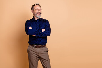 Fototapeta premium Businessman standing against beige background in formal outfit reflecting professional lifestyle and success