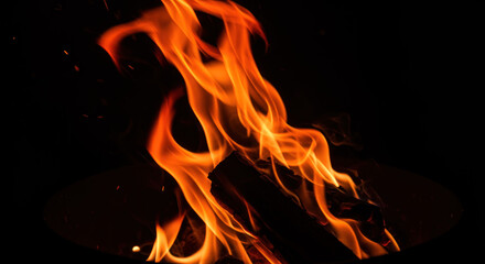 Fototapeta premium A closeup view of a campfire with bright orange flames and glowing embers
