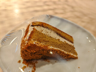 A delicious slice of mocha cake on a plate in a wooden table