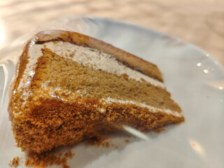 A delicious slice of mocha cake on a plate in a wooden table