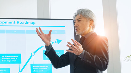 プレゼンテーション、ビジネス、会議、ビジネスマン、セミナー、男性、講師、社長、経営者、重役、エグゼクティブ、発表、ロードマップ、計画、プロジェクト、企画、ベテラン、シニア、ミドルエイジ、中高年、モニター、大画面、スライド、企業、会社、経営、戦略、マネジメント、マーケティング、決算、ミーティング、ビジネスパーソン、提案、JTC、講演、登壇、スピーチ、IR、株主総会、説明会、報告、案内、業績、日本人、