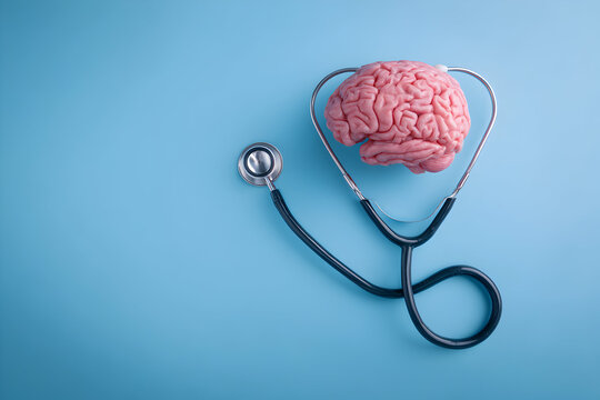 Human brain being examined with a stethoscope on a blue surface, representing mental health and the importance of neurological care in a clean and minimalist style.