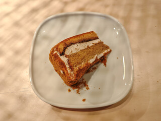 A delicious slice of mocha cake on a plate in a wooden table
