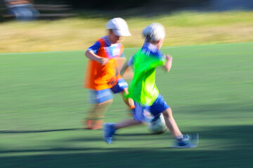 little  boys plays football at a sports school .Blur.