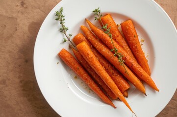 Glazed carrots with honey and fresh thyme served on a dish