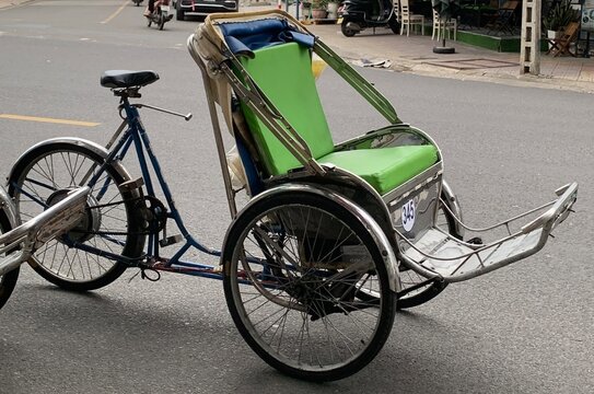 Traditional Vietnamese cyclo rickshaw parked on the street. Local transportation and cultural heritage vehicle in Southeast Asia, used for tourists and city rides.