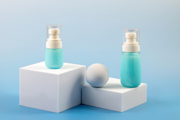 a set of unbranded bottles of cream, lotion or other cosmetics on a catwalk on a blue gradient background.