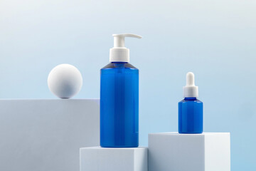 A set of cosmetics, creams and serums. Containers of skin care products on a white podium on a blue background
