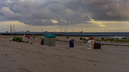 Beach chairs on Borkum beach with view towards Eemshaven and wind turbines