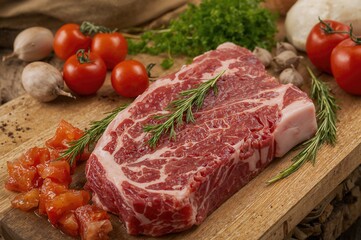 Raw meat accompanied by cooking ingredients on a wooden surface