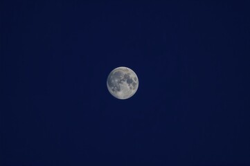 Almost full moon glowing in a deep navy sky